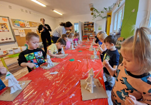 Dzieci wykonują choinkę z gipsowych elementów