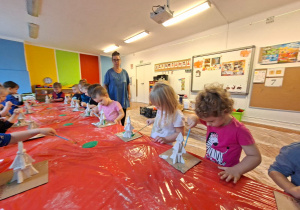 Dzieci wykonują choinkę z gipsowych elementów