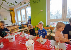 Dzieci wykonują choinkę z gipsowych elementów