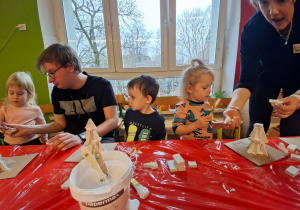 Dzieci wykonują choinkę z gipsowych elementów