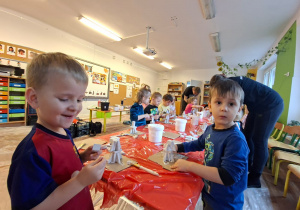 Dzieci wykonują choinkę z gipsowych elementów