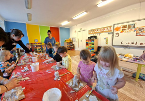 Dzieci wykonują choinkę z gipsowych elementów