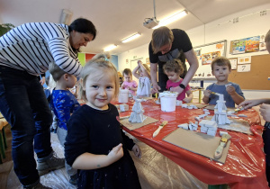 Dzieci wykonują choinkę z gipsowych elementów