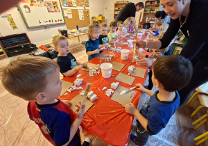 Dzieci wykonują choinkę z gipsowych elementów