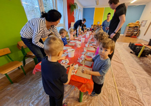 Dzieci wykonują choinkę z gipsowych elementów