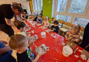 Dzieci wykonują choinkę z gipsowych elementów