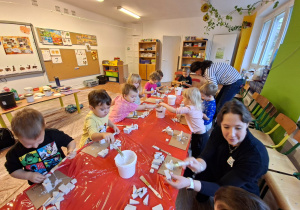 Dzieci wykonują choinkę z gipsowych elementów