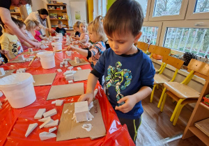 Dzieci wykonują choinkę z gipsowych elementów