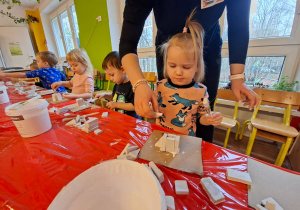 Dzieci wykonują choinkę z gipsowych elementów