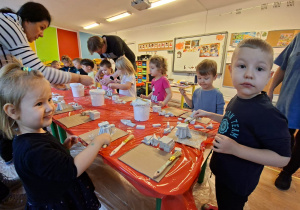 Dzieci wykonują choinkę z gipsowych elementów