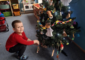 Chłopiec wiesza ozdobę na choinkę