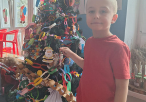 Chłopiec wiesza ozdobę na choinkę