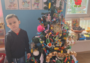 Chłopiec wiesza ozdobę na choinkę