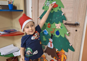 Chłopiec wiesza ozdobę na choinkę