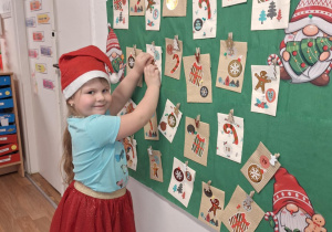 Dziewczynka odkrywa kartkę z kalendarza adwentowego