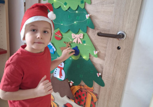 Chłopiec wiesza ozdobę na choinkę