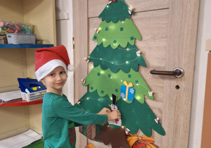 Chłopiec wiesza ozdobę na choinkę