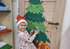 Dziewczynka wiesza ozdobę na choinkę