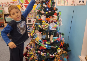 Chłopiec wiesza ozdobę na choinkę