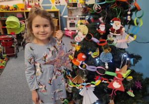 Dziewczynka wiesza ozdobę na choinkę