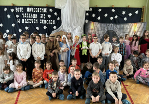 Grupa dzieci na tle dekoracji bożonarodzeniowej