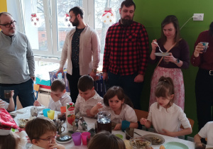 Dzieci i rodzice spożywają posiłek