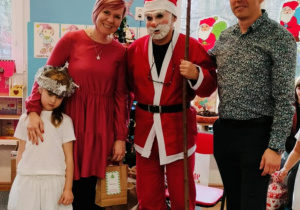 Dziewczynka z rodzicami pozuje do zdjęcia z Mikołajem