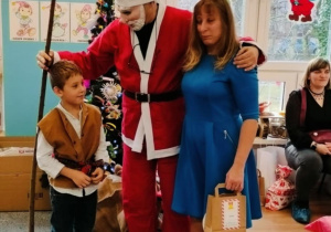 Chłopiec z mamą pozuje do zdjęcia z Mikołajem