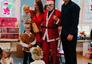 Chłopiec z rodzicami i bratem pozuje do zdjęcia z Mikołajem