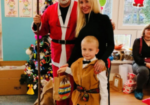 Chłopiec z mamą pozuje do zdjęcia z Mikołajem