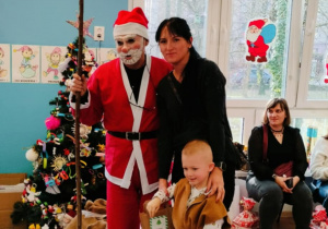 Chłopiec z mamą pozuje do zdjęcia z Mikołajem