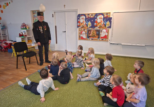 Dzieci słuchają górnika, który opowiada im na czym polega jego praca