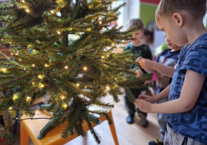 Chłopcy wieszają bombki na choince