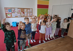 Dzieci pozują do zdjęcia trzymając bombki choinkowe