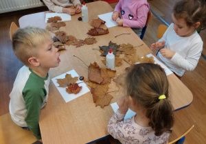 Dzieci tworzą kompozycję z liści i kasztanów