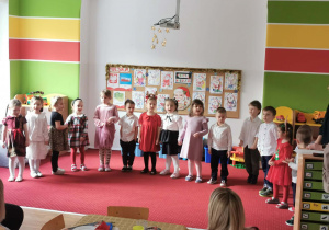 Dzieci stoją w półkolu i śpiewają piosenkę