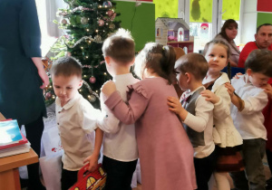 Dzieci czekają w kolejce, żeby odebrać paczkę świąteczną