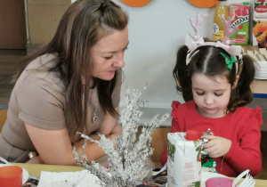 Dziewczynka siedzi przy stole ze swoją mamą