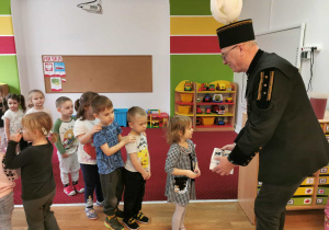 Górnik częstuje dzieci cukierkami