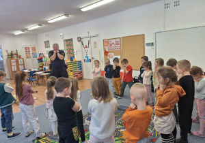 Przedstawiciel Straży Miejskie pokazuje dzieciom pozycje obronną przed atakiem psa