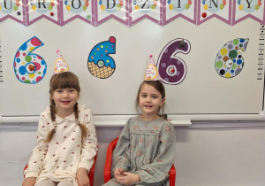 Justyna i marcelina siedzą na krzesełkach i pozują do zdjęcia