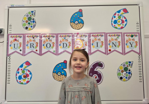 Justyna stoi przy dekoracji i pozuje do zdjęcia