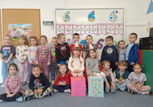 Cała grupa dzieci pozuje do zdjęcia z Justyną i Marceliną