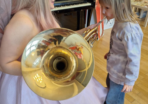 Dziewczynka próbuje grać na puzonie