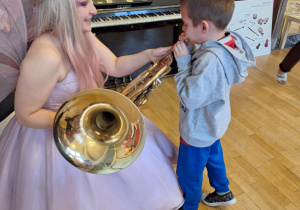 Chłopiec próbuje grać na puzonie