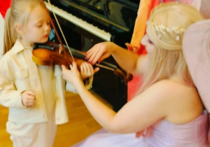 Dziewczynka próbuje grać na skrzypcach