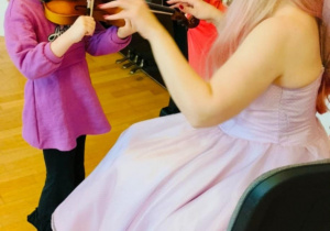 Dziewczynka próbuje grać na skrzypcach