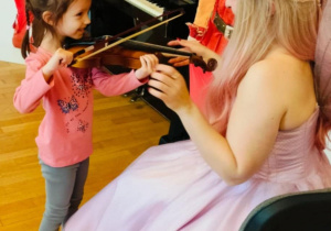 Dziewczynka próbuje grać na skrzypcach