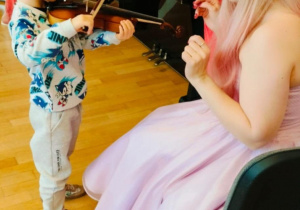 Chłopiec próbuje grać na skrzypcach