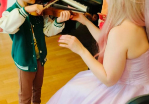 Chłopiec próbuje grać na skrzypcach